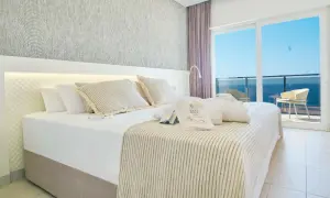 Habitación con cama king, vistas al mar y amenities de Suitopia Spa Calpe.
