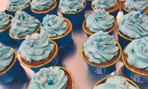 Una fila di cupcake con glassa azzurra e decorazioni a tema invernale. Una deliziosa cupcake ricetta pronta da gustare.