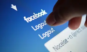 Palec dotyka opcji "Logout" na ekranie telefonu, pokazując, jak wylogować z Facebooka.