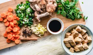 Co jedzą weganie? Tofu, makaron ryżowy, grzyby shiitake, marchew, szczypiorek, czosnek, imbir, kolendra, sos sojowy i przyprawy.