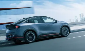 En blå Nissan Leaf 2026 glider fram på en motorväg med en stadssilhuett i bakgrunden.
