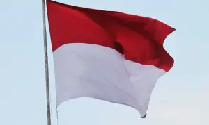 Flaga Indonezji powiewa na wietrze, ukazując swoje dumne czerwono-białe barwy na tle błękitnego nieba.