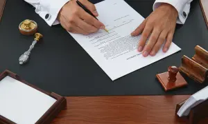 Podpisanie testamentu, kluczowego dokumentu do dziedziczenia mieszkania, z pieczęcią i atramentem.