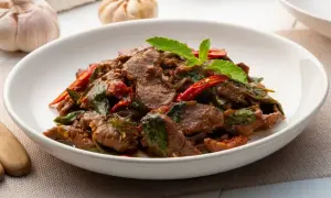Aromatyczne wołowina po chińsku z bazylią i papryczką chili, podana w białej misce.