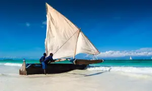 Dhow na plaży, gotowy do rejsu. Zastanawiasz się, ile się leci na Zanzibar? Ta łódź oferuje alternatywną, morską podróż.