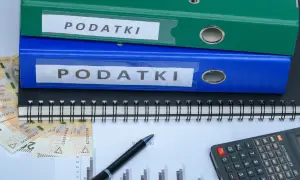 Segregator z napisem "PODATKI", pieniądze, kalkulator i wykres. Szukasz sposobu, jak zmniejszyć podatek za budynki gospodarcze?