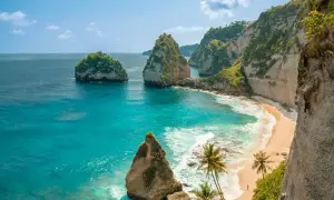 Rajska plaża na Bali w lipcu. Turkusowa woda, biały piasek, klify i palmy tworzą idealny krajobraz.