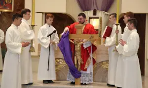 Podczas wielki piątek msza, kapłan prezentuje krzyż z figurą Chrystusa. Ceremonii towarzyszą ministranci w białych szatach.