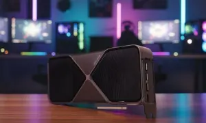 Najnowsza karta graficzna RTX 5090 na drewnianym blacie, w tle gamingowy setup z kolorowymi światłami RGB.