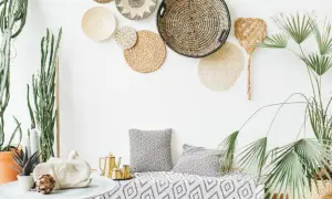 Wnętrze w stylu boho chic: plecione kosze na ścianie, sukulenty, złoty czajniczek i poduszki z geometrycznym wzorem.