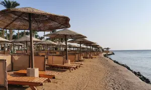 Plaża w Egipcie z rzędami leżaków i parasoli. Zastanawiasz się, ile kosztuje wiza do Egiptu, by tu wypocząć?