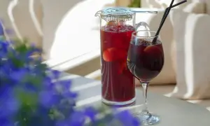 Orzeźwiający drink z czerwonym winem, owocami i lodem, podany w szklance i dzbanku, gotowy do degustacji w letni dzień.