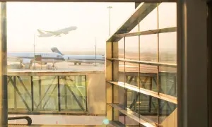 Flugzeuge starten und landen am Flughafen. Ein Flugzeug hebt ab, während andere am Gate warten. Gut, dass ich weiß, wie viel eher am Flughafen sein muss.