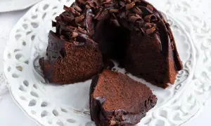Pyszna babka z mascarpone i kakao, polana czekoladą i posypana wiórkami.