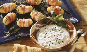 Leckere Kartoffeln im Speckmantel mit Kräutern und einem Dip.