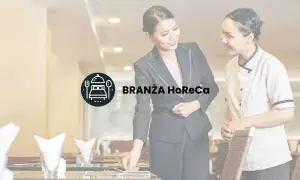 Dwie kobiety w restauracji, symbolizujące branżę HoReCa, przygotowują stolik.