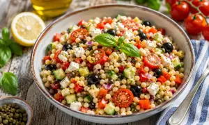 Bunter Salat mit Fregola Sarda, Tomaten, Gurken, Oliven und Feta. Ein köstliches fregola sarda rezept für den Sommer.