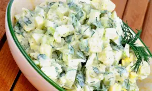Kartoffelsalat mit Joghurt, Eiern und Gurken, garniert mit Dill. Ein leichter und erfrischender Salat.