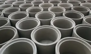 Rzędy betonowych kręgów, gotowych do budowy studni kręgowej.