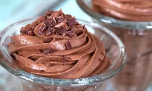 Zarte Mousse au Chocolat, gekrönt mit Schokoladenstückchen, in einem Glas serviert. Ein Genuss für Schokoladenliebhaber.
