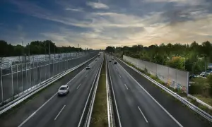 Szeroka autostrada bursztynowa z ruchem samochodowym pod pochmurnym niebem.