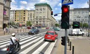 Sygnalizator S2 z czerwonym światłem dla samochodów i zieloną strzałką dla skręcających w prawo. Ruchliwe skrzyżowanie w mieście.