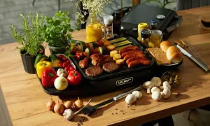 Pyszne kiełbaski, burgery i szaszłyki na grillu. Idealne składniki na to, co na grilla tanio i smacznie. Warzywa, pieczywo i dodatki dopełniają obraz.