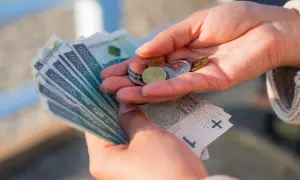 Dłonie liczą pieniądze, symbolizując oszczędności na przyszłość, być może związane z wiekiem emerytalnym kobiet.