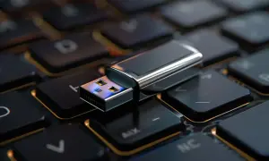 Pendrive leżący na klawiaturze komputera.