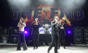 Członkowie Black Sabbath na scenie podczas koncertu "The End". Ozzy Osbourne z mikrofonem, pozostali członkowie klaszczą.