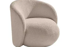 En mjuk och inbjudande teddyfåtölj i ljusbeige färg, perfekt för mysiga hemmakvällar.