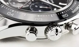 Detalle de un reloj de lujo, mostrando el bisel con números y marcas, y los pulsadores. El bisel del reloj está diseñado para cambiar la hora.