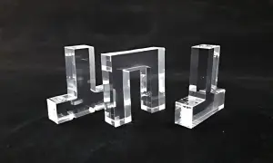 Tre forme geometriche trasparenti, realizzate in materiale acrilico, su sfondo nero.