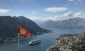 Montenegro backpacking: Fahne weht über Bucht mit Kreuzfahrtschiff und Bergen. Traumhafter Ausblick!