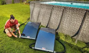Mann schließt Solarmatten an, um den Pool zu heizen.
