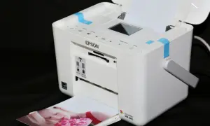 Biała drukarka Epson PictureMate PM 245 drukuje zdjęcie kobiety z różami. Szukasz, jaka drukarka najtańsza w eksploatacji?