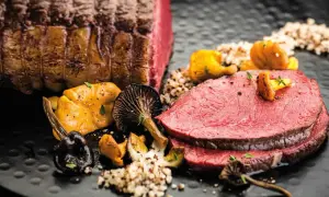 Zarter Rinderbraten im Ofen, perfekt geschnitten, serviert mit Pilzen und Quinoa. Ein Festmahl!