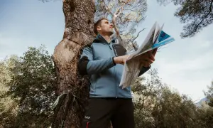 Un randonneur consulte une carte IGN pour s'orienter. C'est quoi une carte IGN ? C'est l'outil indispensable pour explorer la nature.