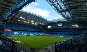 Pusta, błękitna trybuna stadionu Lecha Poznań, gotowa na przyjęcie kibiców. Pojemność stadionu robi wrażenie.