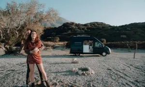Glückliches Paar mit Hund im Campervan, genießt eine Kreta Rundreise auf eigene Faust am Strand.
