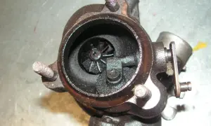 Turbocompresseur usagé, avec une durite turbo percée visible. L'intérieur est encrassé.