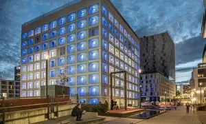 Die Stadtbibliothek Stuttgart leuchtet in der Dämmerung mit blauen Fenstern.