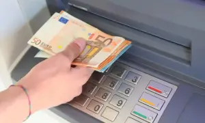 Ręka z banknotami 50 euro przy bankomacie. W Hiszpanii, jak w całej strefie euro, obowiązuje euro.