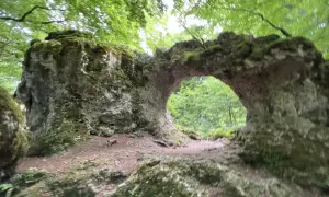 Arco natural cubierto de musgo en la sierra de Entzia, ideal para rutas de senderismo.