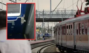 Zbliżenie na mechanizm drzwi pociągu, pokazujący, jak otworzyć drzwi w pociągu, z widokiem na peron i tory.