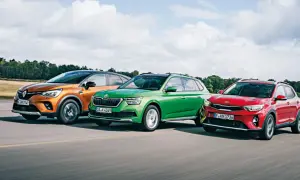 Trzy miejskie crossovery: pomarańczowy Renault, zielona Skoda i czerwony Kia Stonic 2024 jadą po drodze.