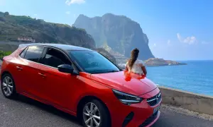 Roter Opel auf Madeira, bereit für eine Fahrt entlang der Küste mit Blick auf die dramatischen Berge und das blaue Meer.