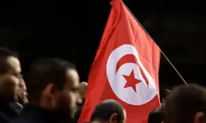 Flaga Tunezji powiewa wśród tłumu. Czy Tunezja jest bezpieczna? Ludzie z flagą, symbol nadziei i jedności.