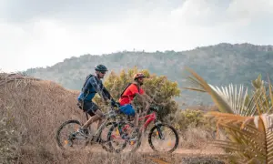 Dwóch mężczyzn na rowerach górskich w terenie. Jazda na rowerze może być pomocna przy gonartrozie, jeśli jest wykonywana z umiarem.