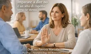 Una donna alza la mano in segno di stop, mostrando la psicologia del non saper dire di no. È un atto di rispetto verso se stessi.